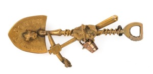 An antique gold miner's brooch, crossed pick and shovel with gold nugget specimens, stamped "South Africa", 5.5cm wide, 5 grams