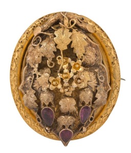 An impressive Australian Colonial yellow gold oval brooch adorned with leaves and forget-me-nots set with red stones. The reverse with lock of hair in mourning window, circa 1860s, 5cm high, 19.5 grams total