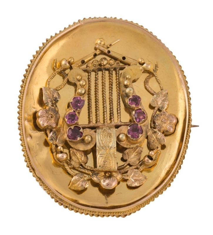 An antique Australian Colonial yellow gold oval brooch adorned with a lyre set with rubies, the reverse with mourning window, circa 1860s, 3.3cm high, 8.3 grams total