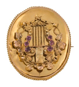 An antique Australian Colonial yellow gold oval brooch adorned with a lyre set with rubies, the reverse with mourning window, circa 1860s, 3.3cm high, 8.3 grams total