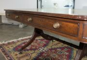 A George III English mahogany library table with embossed green leather top, attractive rounded corners with two drawers and four simulated drawer fronts to the ends and sides, supported on two double concave reeded trestles forming attractive splay legs - 8