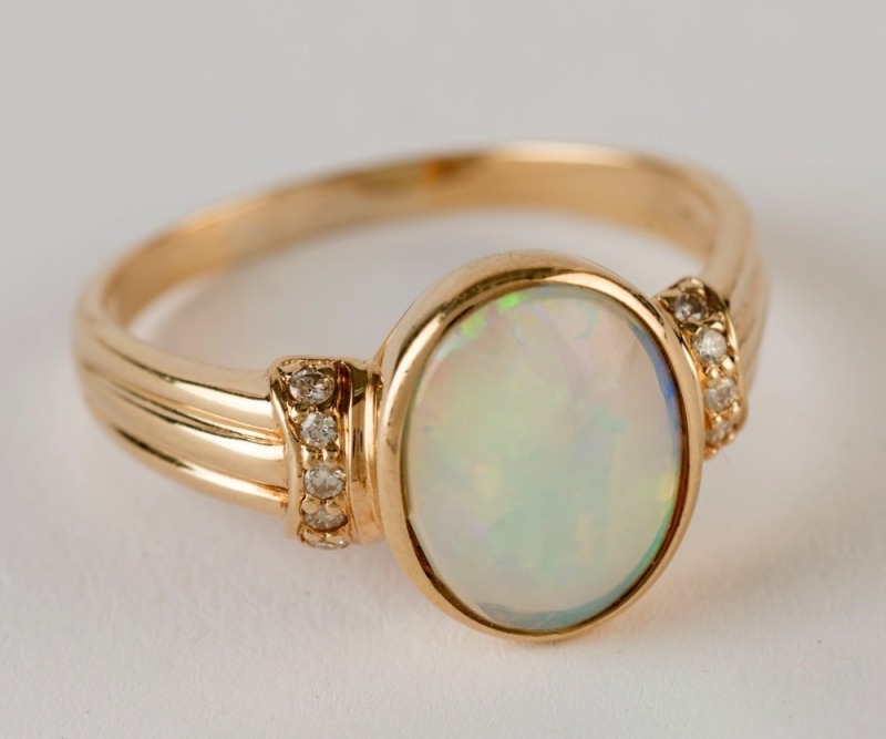 A yellow gold ring set with a solid opal flanked by diamonds, 20th century, 4 grams total