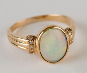 A yellow gold ring set with a solid opal flanked by diamonds, 20th century, 4 grams total