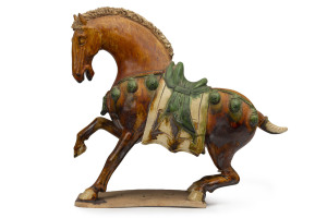 A Sancai glazed pottery horse statue, Tang Dynasty style, 19th century, 27cm high, 30cm long. PROVENANCE: The Joshua McClelland Collection, Melbourne