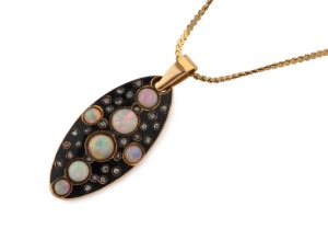 An antique yellow gold oval pendant set with cabochon opals and diamonds in black enamel, 19th century. Later 14ct Italian gold necklace, the pendant 3cm high, 6.4 grams total including the chain