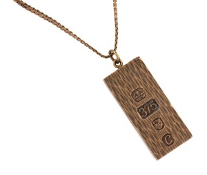 An English 9ct rose gold one oz. ingot pendant on a 9ct rose gold chain, 20th century, the ingot 3,5cm high, the chain 46cm long, 35 grams total