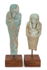 A pair of  Egyptian glazed faience Ushabti figures of classic forms wearing wigs and beards, each holding the crook and flail, the front surface with horizontal bands of hieroglyphs. Late Period, circa 600 to 300 B.C.,   17cm high 14cm high