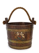 An antique oak and brass bucket of coopered construction with rope handle and hand-painted crest, 19th century, ​​​​​​​32cm high