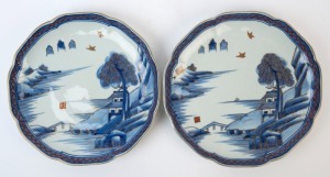 Pair of Chinese porcelain platters with underglaze blue landscape decoration, red borders and gilded highlights, early 20th century, 31.5cm wide