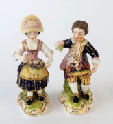 A pair of antique continental porcelain statues of a young man and woman with fruit and flowers, 19th century, 12cm and 12.5cm high