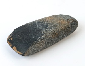 A Neolithic axe head, ground and polished basalt. Together with a hand-written note by the previous collector. Xian, China, circa 8,000 B.C.  14 cm long