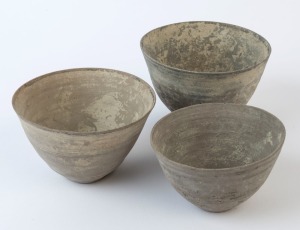 A group of three Indo-Persian pottery vessels with incised bands around the outer surfaces. Intact; earth accretions evident. Baluchistan, circa 2nd millennium B.C., 8cm high