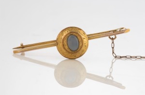 An antique yellow bar brooch set with moonstone, late 19th century, 4.5cm wide, 3.5 grams total