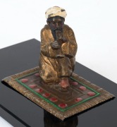 An Austrian cold painted bronze statue of an Arab sitting on a Persian carpet, mounted on a black glass plinth, early 20th century, ​​​​​​​6cm high, 13.5cm wide, 7cm deep - 2