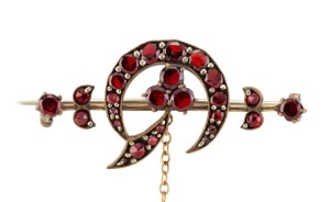 An antique 9ct yellow gold crescent and bar brooch set with garnets, late 19th early 20th century, 4cm wide, 3.8 grams