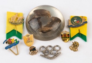 BADGES: Selection with RUGBY UNION pin badges for 1889-1964 75th Anniversary of Springboks v Australia matches, plus a Wallabies 'Kangaroo & Rugby Ball' badge, both mounted on felt; OLYMPIC/COMMONWEALTH GAMES with 1956 Melbourne Olympics 'Rings over Boomerang' pin badge (colour loss), two Kenya 2006 Commonwealth Games lapel badges, Sydney 2000 Olympic pin badge, plus 2 others; also MOTOR RACING: encapsulated fragments of Dick Johnson's 1983 Race Car