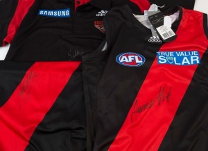 ESSENDON: James Hird signature on Adidas polo/coach's shirt (size L) and on 2013 guernsey (size S); also Jobe Watson signature on 2013 guernsey (size XL). (3)