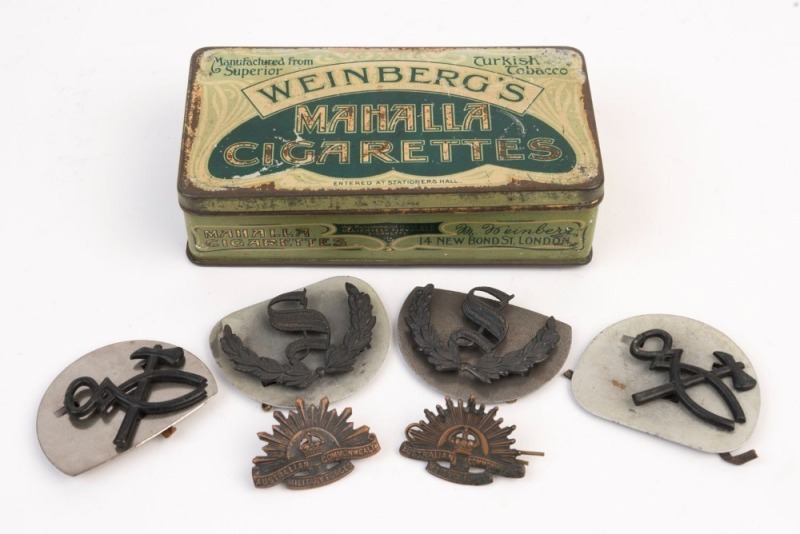 Six assorted military badges housed in an antique Turkish tobacco cigarette tin, (7 items), ​​​​​​​the tin 17cm wide