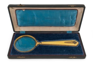 A magnificent Imperial Russian silver-gilt, gold plated and enamelled magnifying glass, in original satin-lined case. The enamelled handle set with small diamond roses and garnet cabochons. Hallmarked "84" and "A*H" for FABERGE Workmaster August Frederik Hollming (born in Finland, 1854; settled in St. Petersburg 1876, becoming a Faberge workmaster in 1880). 27.5cm long; the case 31 x 14cm.
