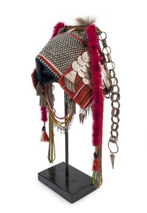 AKHA 'PHAMI' HEADDRESS: Made from Yunnan "Dragon" coins, 19th century Burmese glass beads, hand-made silver moon-shaped buttons, chains, pendants, tassels; gibbon fur; red-dyed chicken hackles and horsehair. circa 1930s.