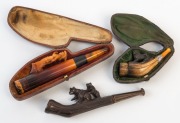 CHEROOT HOLDERS, three antique examples including Meerschaum and Black Forest, (two cased), 19th century, ​​​​​​​the largest 12cm long