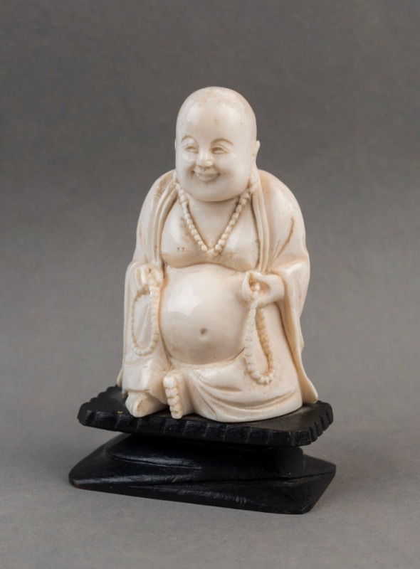 A Chinese ivory statue of a seated Buddha on a carved timber stand, Republic period, 10cm high overall