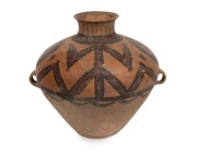  A Chinese lugged Neolithic painted clay vessel with geometric designs within spheres and large stylized figures extend upwards towards the flared spout. Neolithic Culture, circa 3rd to 2nd millennium B.C. 37cm high