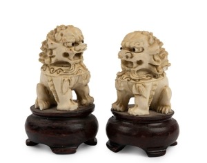 A pair of antique Chinese carved ivory Foo dogs on turned wooden stands, 19th/20th century, ​​​​​​​8cm high overall