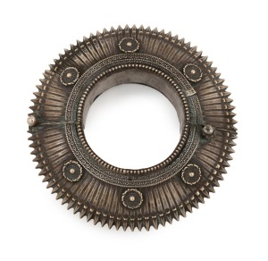 An antique Indian silver bracelet (kataria), Orissa origin, 19th/20th century. Note: This bracelet form is inspired by Vishnu's serrated-edged weapon (chakra); a steel disc with a central hole and a sharpened edge, twirled rapidly on a forefinger and hurled at an adversary. 11cm diameter, internal 5cm diameter, 127 grams. PROVENANCE: Private Collection, Melbourne.