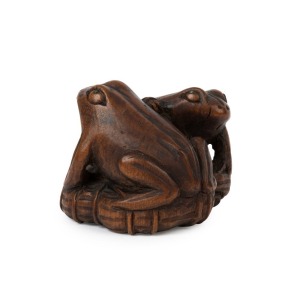 An antique Japanese carved boxwood netsuke of two frogs on a lotus leaf, signed Katakuni, Meiji period, 19th century, 3cm high, 4.8cm wide