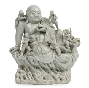 Blanc de chine Chinese porcelain statue of a Buddha surrounded by boys 19th/20th century,square seal mark to back,24.5cm high