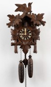 A German Cuckoo twin weight wall clock with carved leaves and birds, 20th century, 40cm high