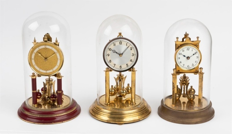 Three German 400 day anniversary clocks in glass domes, 20th century, ​​​​​​​the largest 31cm high