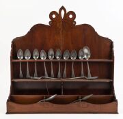 A Georgian mahogany spoon rack and fourteen assorted pewter spoons, 18th and 19th century, ​​​​​​​the rack 66cm high, 63cm wide, 16cm deep