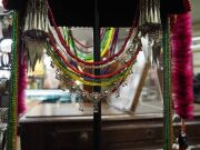 AKHA 'PHAMI' HEADDRESS: Made from Yunnan "Dragon" coins, 19th century Burmese glass beads, hand-made silver moon-shaped buttons, chains, pendants, tassels; gibbon fur; red-dyed chicken hackles and horsehair. circa 1930s. - 7