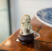 A pair of antique Chinese carved ivory Foo dogs on turned wooden stands, 19th/20th century, ​​​​​​​8cm high overall - 5