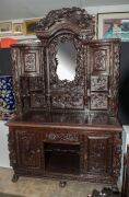 An antique Chinese sideboard, ornately carved with ebonised finish, 19th/20th century, 210cm high, 152cm wide, 68cm deep