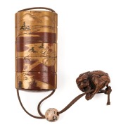 An antique Japanese inro, lacquered cherry wood with gilded landscape scene, with ceramic ojime&nbsp;and Foo dog carved boxwood netsuke, Meiji period, ​​​​​​​the inro 9cm high