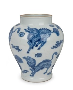 A Chinese blue and white porcelain vase decorated with mythical Buddhist dogs and clouds, 20th century, four character underglaze blue Kangxi mark, ​​​​​​​28cm high