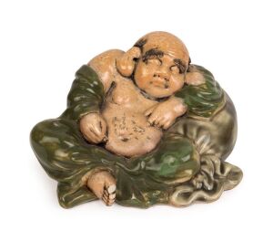 A Chinese porcelain statue of a sleeping Buddha in green robes, Republic period, 13cm high, 22cm wide