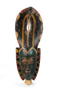 A tribal mask, carved wood with polychrome finish, West African origin, 64cm high 