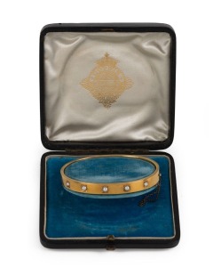 An elegant 18ct yellow gold bangle, set with five natural pearls, by the noted jewellers GODWIN of High Holborn, London, circa 1880s. Housed in original plush fitted box. Godwin traded from this address from 1791 to 1906. 6cm wide, 13.5 grams total