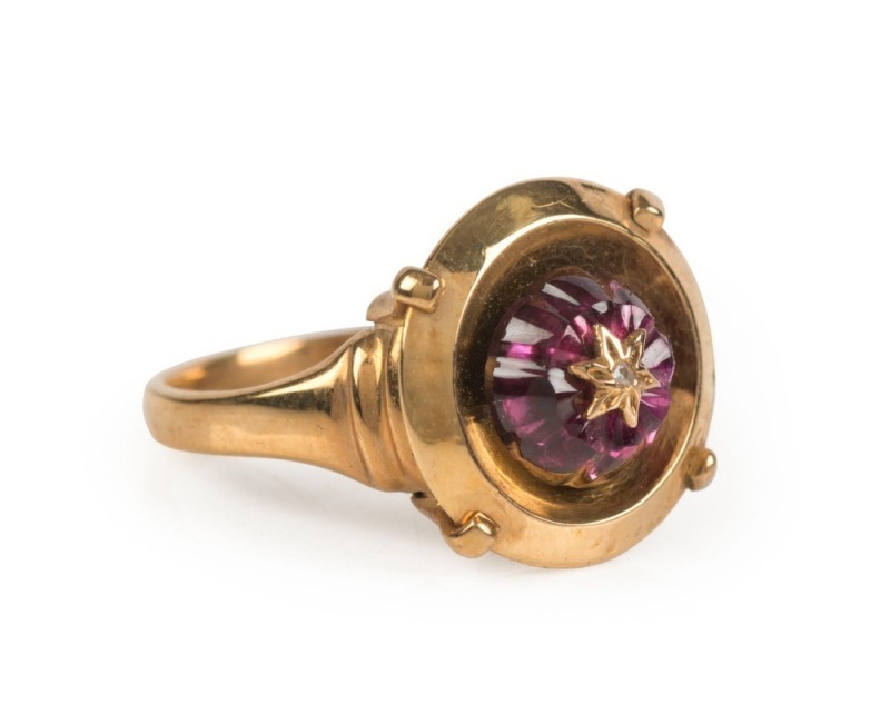 An antique 9ct yellow gold ring of circular design set with a large garnet adorned with a diamond set within a gold star, 19th century, ​​​​​​​4.5 grams total