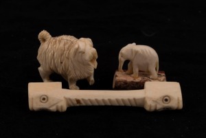 Carved ivory knife rest, dog ornament and carved elephant ornament, 19th and 20th century, (3 items), the knife rest 9cm long