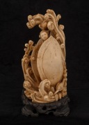 A Chinese carved ivory statue of a female standing nude in waves and clam&nbsp;shell, on wooden stand, early to mid 20th century, 22cm high overall