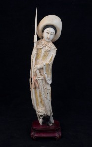 A Chinese carved ivory statue of a standing warrior wearing a hat, on wooden stand, early to mid 20th century, 27.5cm high overall