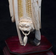 A Chinese carved ivory statue of a standing warrior&nbsp;wearing a hat, on wooden stand, early to mid 20th century, 27.5cm high overall - 2