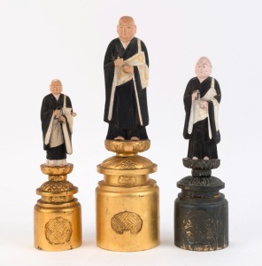 Group of three Japanese Buddhist monk statues, carved wood with polychrome finish and gilded decoration, 20th century, the largest 30.5cm high