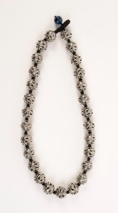 Chinese silver bead necklace, threaded on black silk knotted cord with glass bead clasp, 48cm long