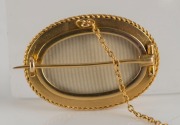 An Aesthetic Movement 18ct yellow gold oval brooch set with three diamonds, housed in a plush fitted box, circa 1870s. Reverse with locket window back. 4cm wide, 14 grams total - 3